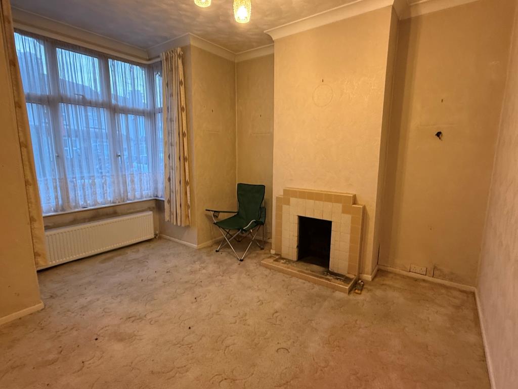 Lot: 154 - TWO-BEDROOM END-TERRACE HOUSE FOR IMPROVEMENT - Carpeted lounge with fireplace and window